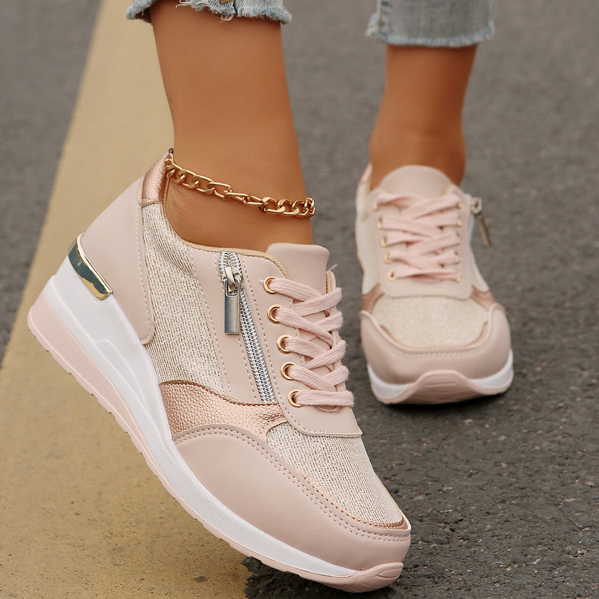 Pink sneakers with gold accents worn on a blurred street background