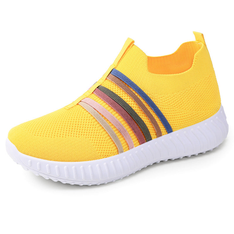 Yellow slip-on sneaker with colorful stripes on a white background