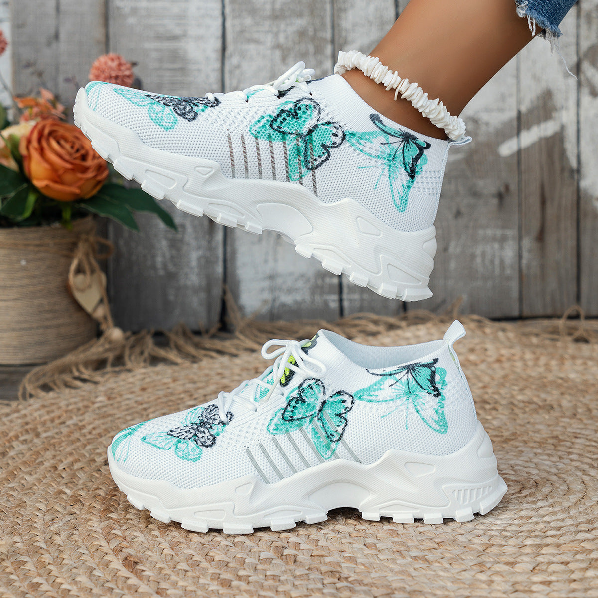 White sneakers with butterfly designs on a woven surface.