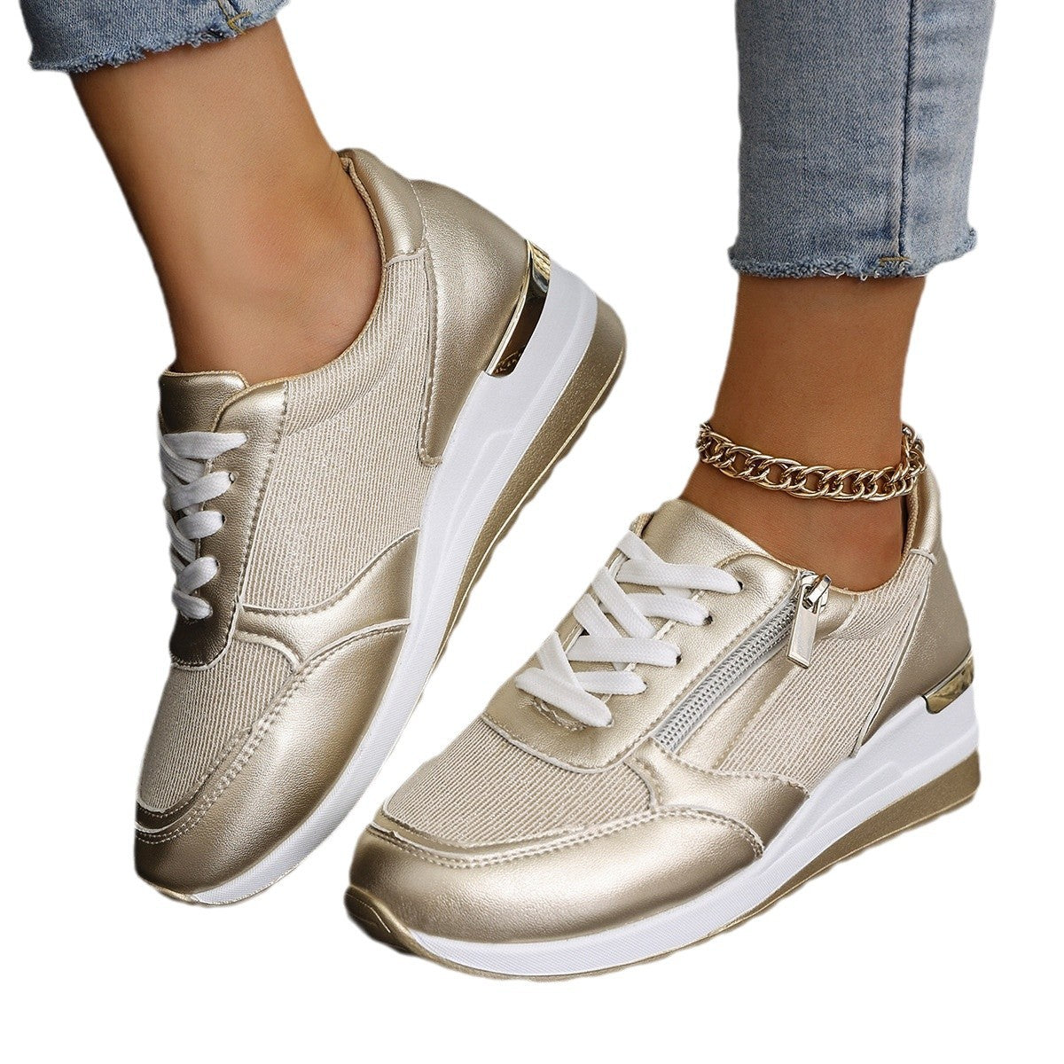 Gold sneakers with white soles worn by a person on a white background